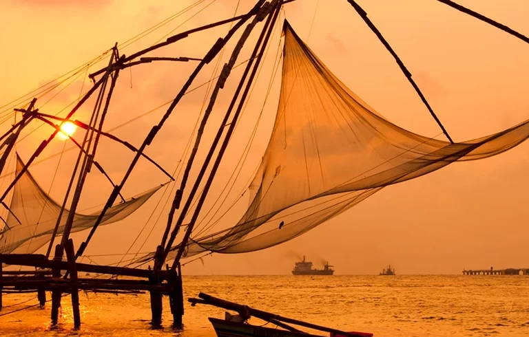 Sunset over Chinese Fishing nets and boat in Cochin (Kochi), Kerala, India.