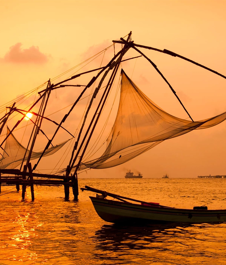 Sunset over Chinese Fishing nets and boat in Cochin (Kochi), Kerala, India.