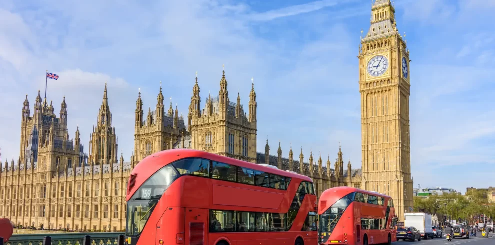 Houses of Parliament with Big Ben and double-decker buses on Westminster bridge, London, UK