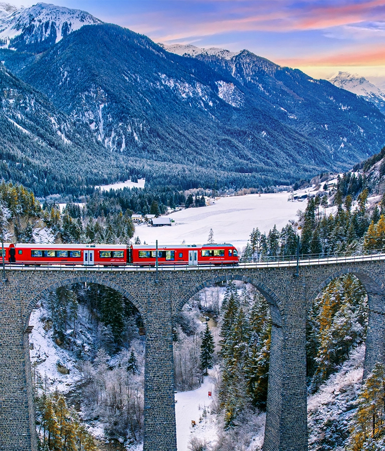 Aerial view of Train passing through famous mountain in Filisur, Switzerland. Landwasser Viaduct world heritage with train express in Swiss Alps snow winter scenery.